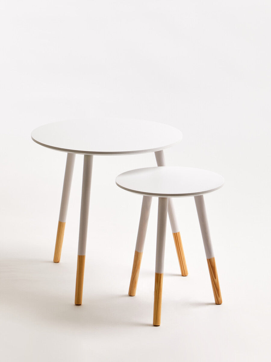Set of two white round nesting side tables with minimalist design gray legs and natural wood feet for modern spaces