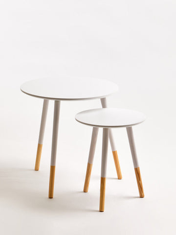 Set of two white round nesting side tables with minimalist design gray legs and natural wood feet for modern spaces