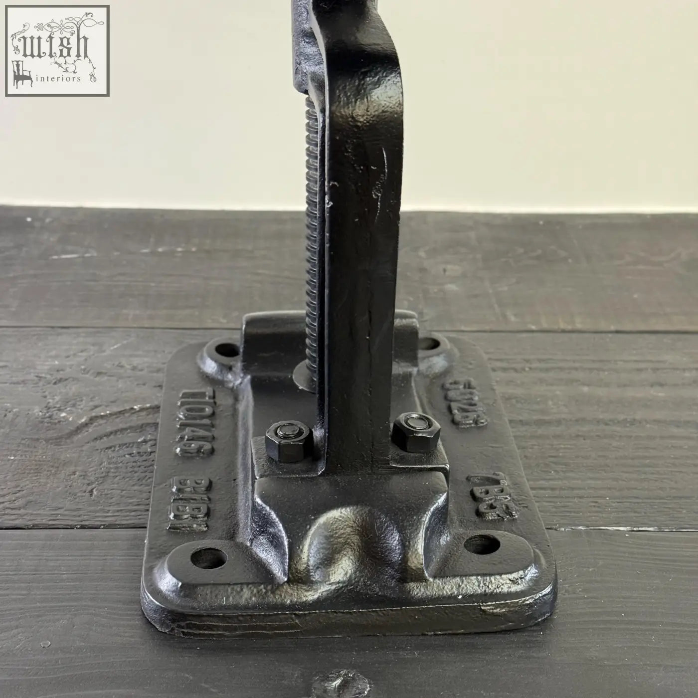 Black cast iron industrial-style wall hook with textured matte finish and embossed branding for vice clamp bar stool
