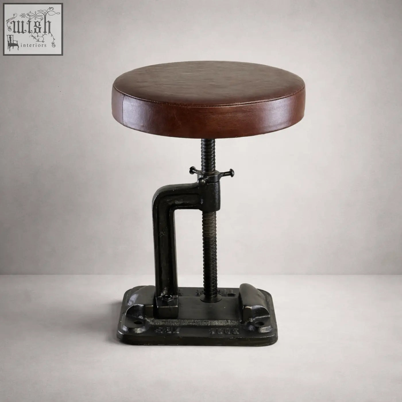 Brown leather-topped vice clamp industrial bar stool with black cast iron frame and adjustable height mechanism