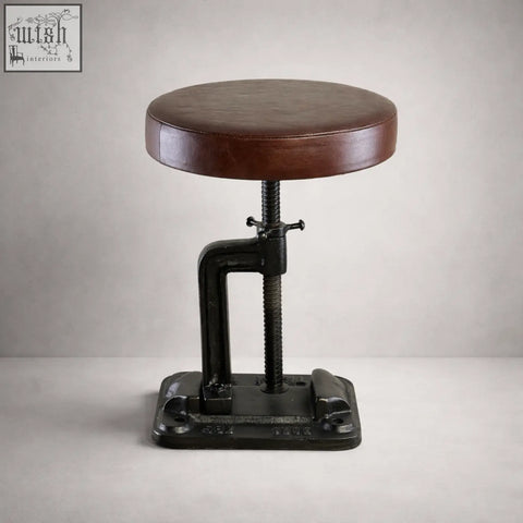 Brown leather-topped vice clamp industrial bar stool with black cast iron frame and adjustable height mechanism