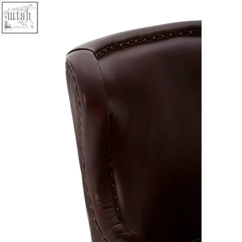 Dark brown leather lounge chair armrest with visible stitching and walnut wood legs in victor brown leather lounge chair