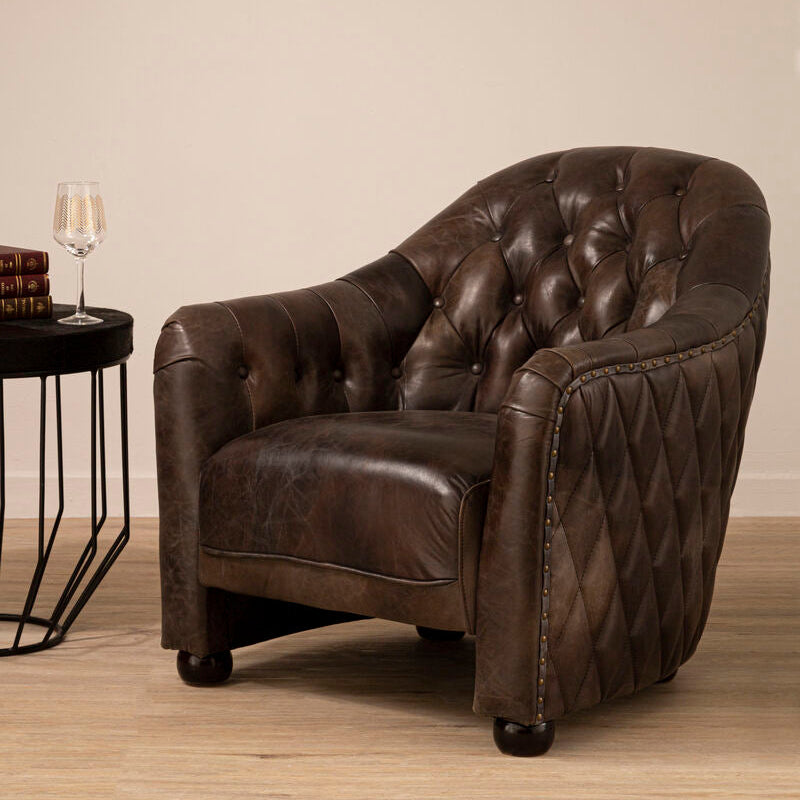 Brown leather tub chair with diamond quilted panels and brass nailhead trim for stylish comfort