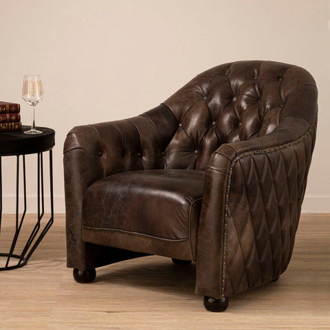 Brown leather tub chair with diamond quilted panels and brass nailhead trim for stylish comfort