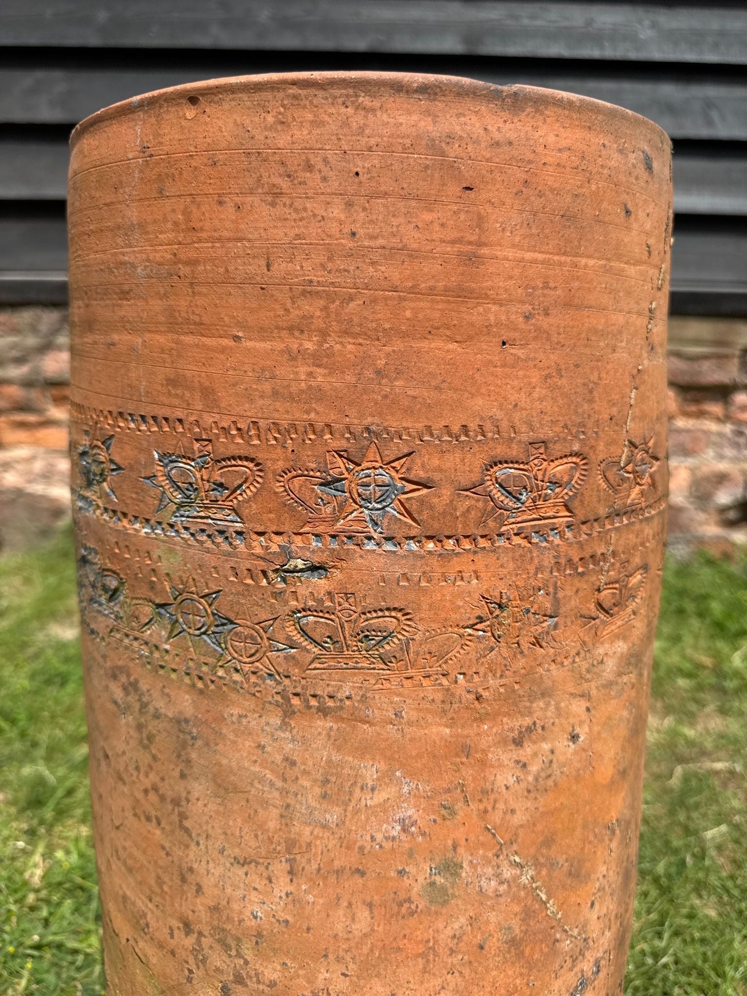 Victorian terracotta chimney pot with embossed crown and star motifs in a rustic weathered finish for garden planter