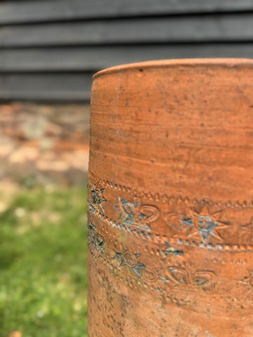 Victorian terracotta chimney pot garden planter with embossed floral and sun motifs in warm earthy orange hue