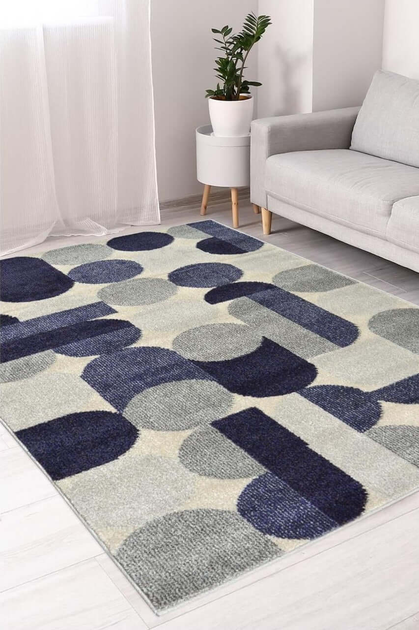 Modern geometric villa blue abstract rug with bold navy blue gray and cream circular and rectangular patterns on plush surface