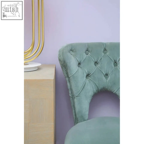 A tufted dining chair in mint green velvet with curved backrest and button detailing perfect for velvet tufted dining seating
