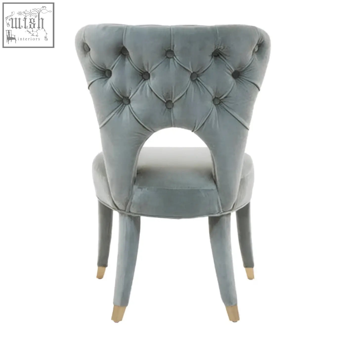 A tufted gray velvet dining chair with a curved back and gold-tipped legs perfect as a velvet tufted dining seat