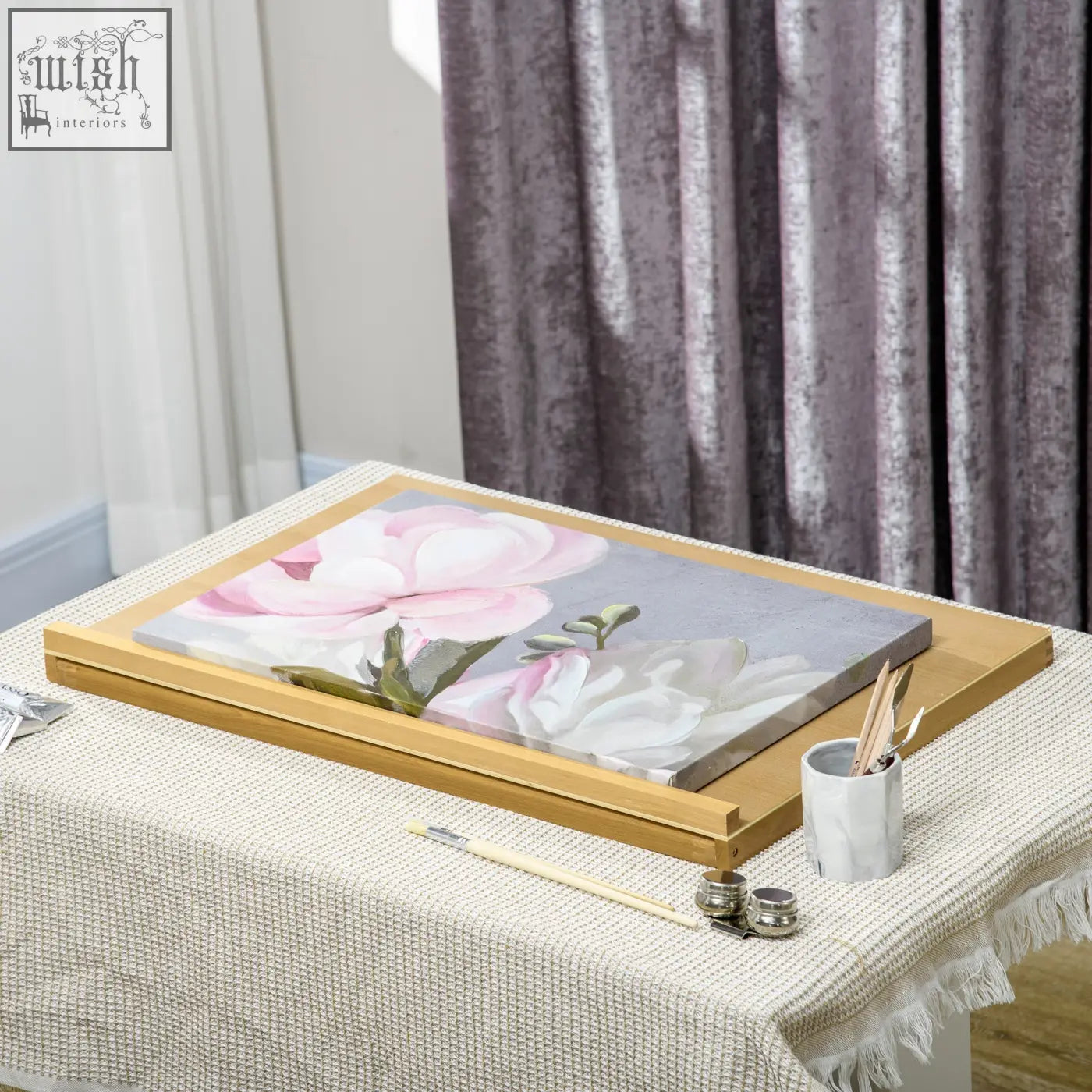 Framed canvas painting of pink and white magnolia flowers on a light gray background in a portable folding beechwood table easel with adjustable angle