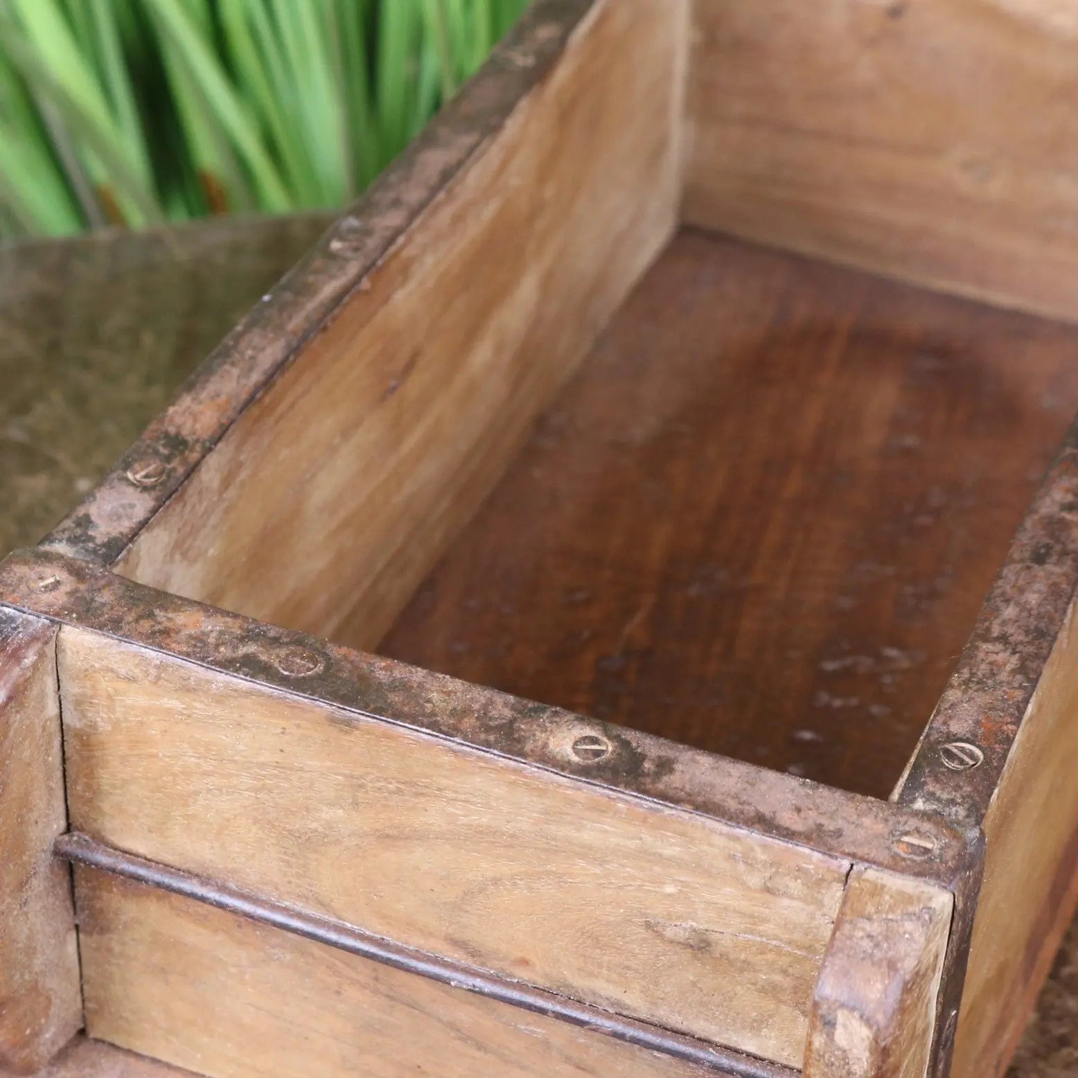A vintage brick mould wooden rustic crate with weathered metal reinforcements and a dark worn finish