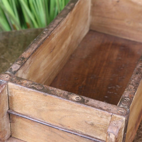 A vintage brick mould wooden rustic crate with weathered metal reinforcements and a dark worn finish