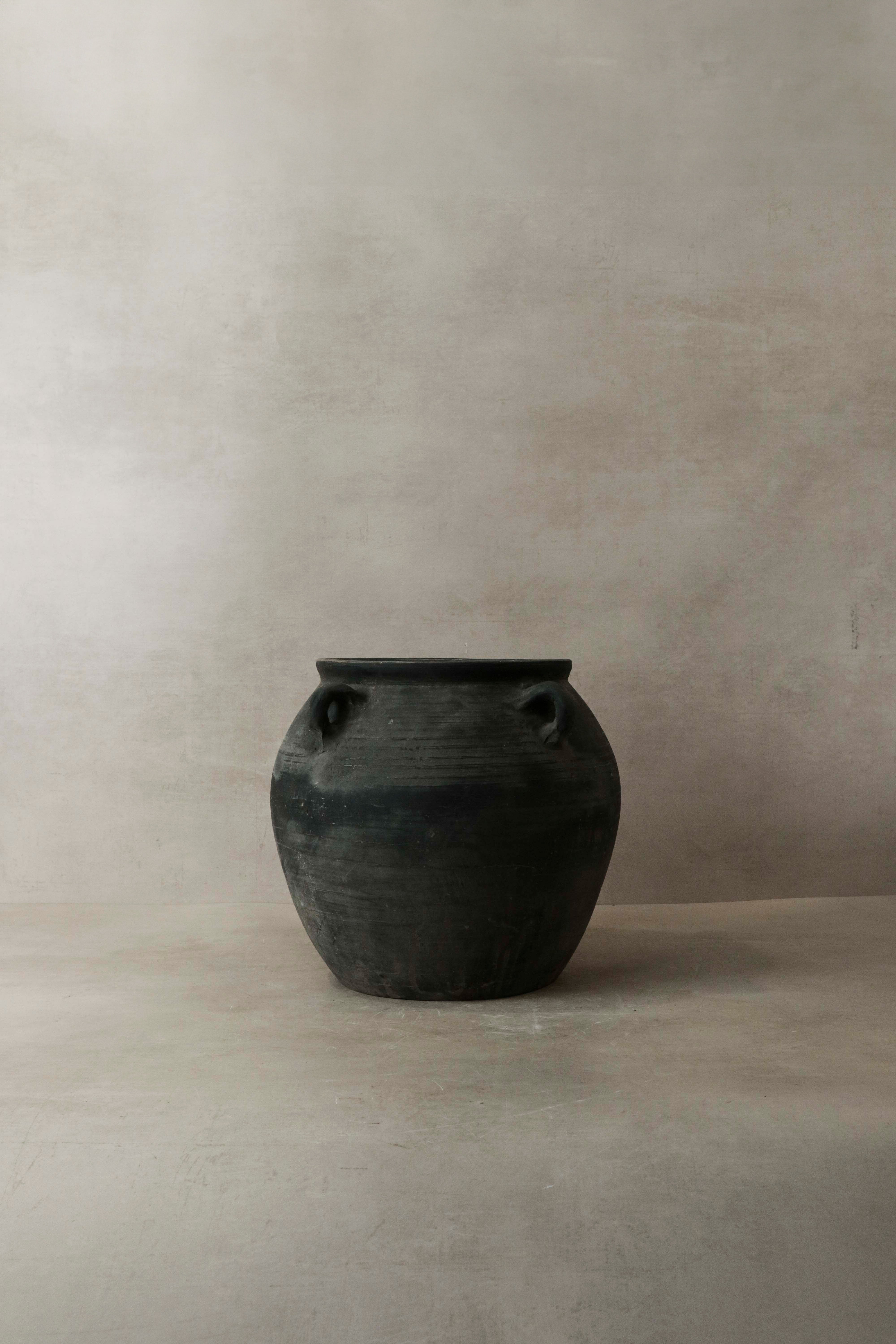 Vintage dark ceramic jar with two small handles on either side perfect for rustic home decor