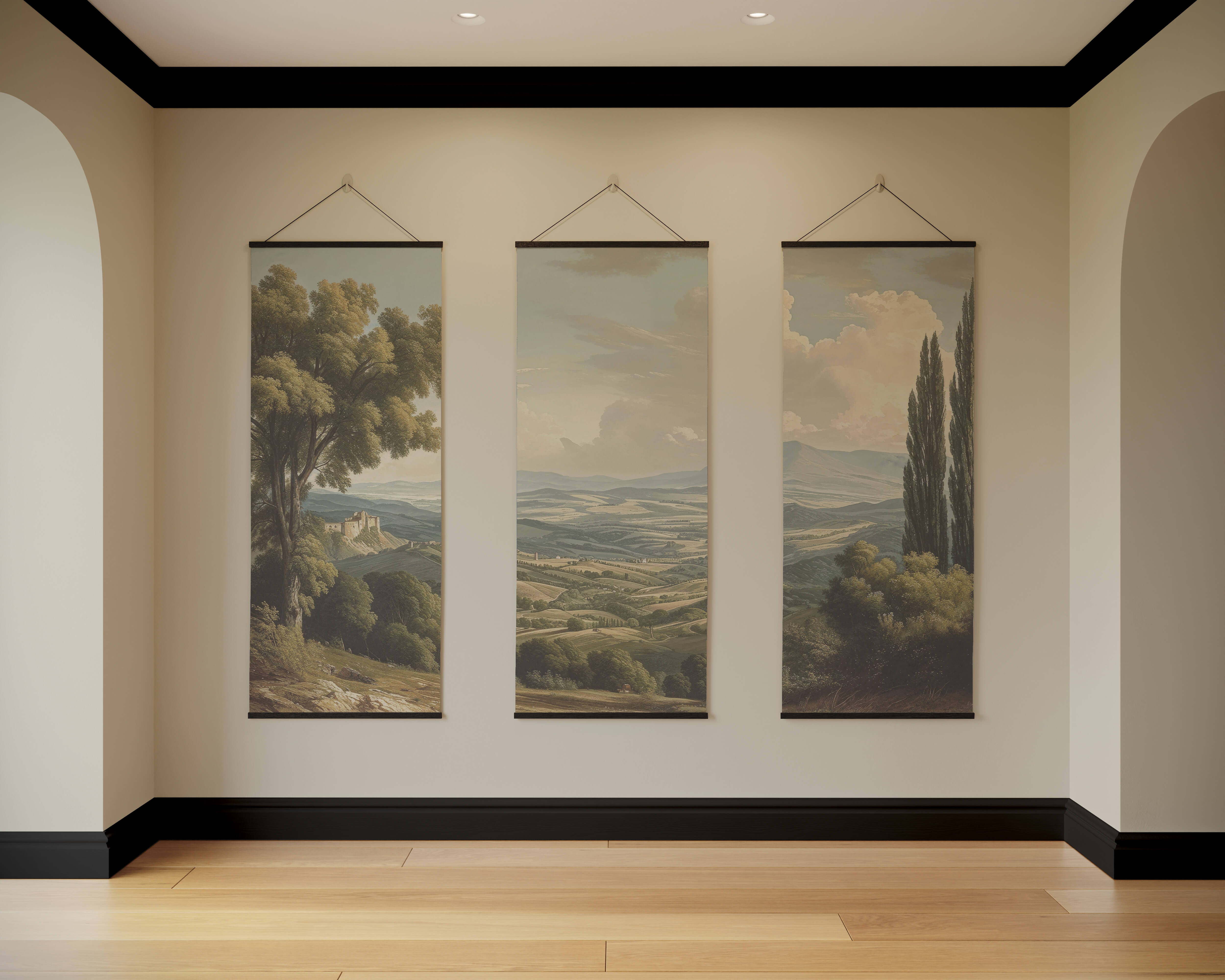 Three vintage european landscape tapestries with muted earth tones of rolling hills hang on a light wall
