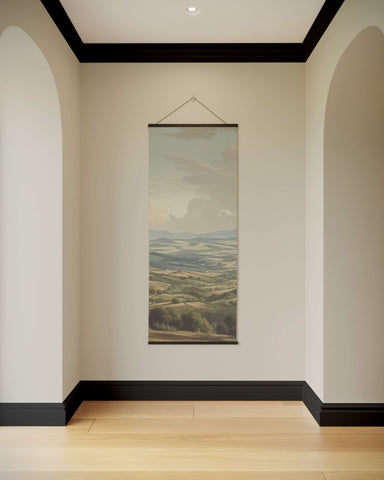 A vintage european landscape tapestry print with soft earthy tones and rolling hills framed in dark wood