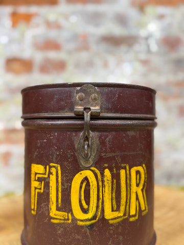 Vintage maroon galvanized metal flour bin with yellow label and aged brass latch for storage use