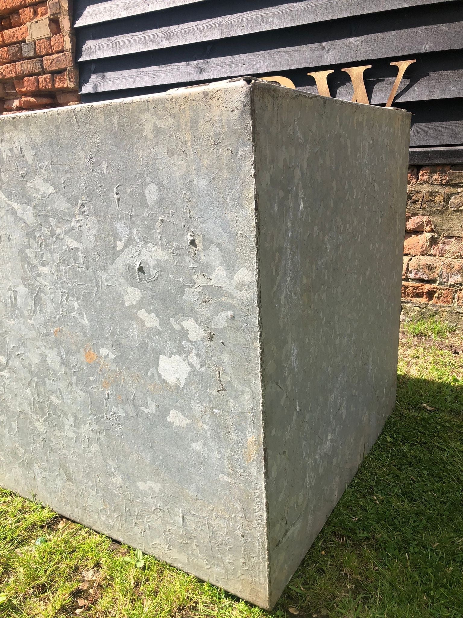 Vintage galvanised metal trough planter in weathered gray with rough texture ideal for herb garden or raised bed pond
