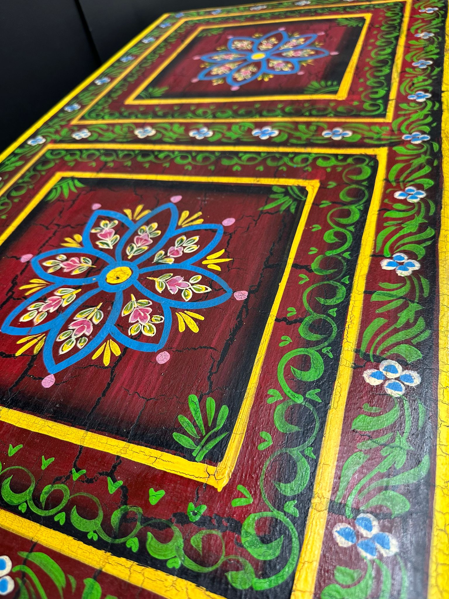 Vintage indian hand painted wooden coffee table with vibrant red floral and vine designs for living room use