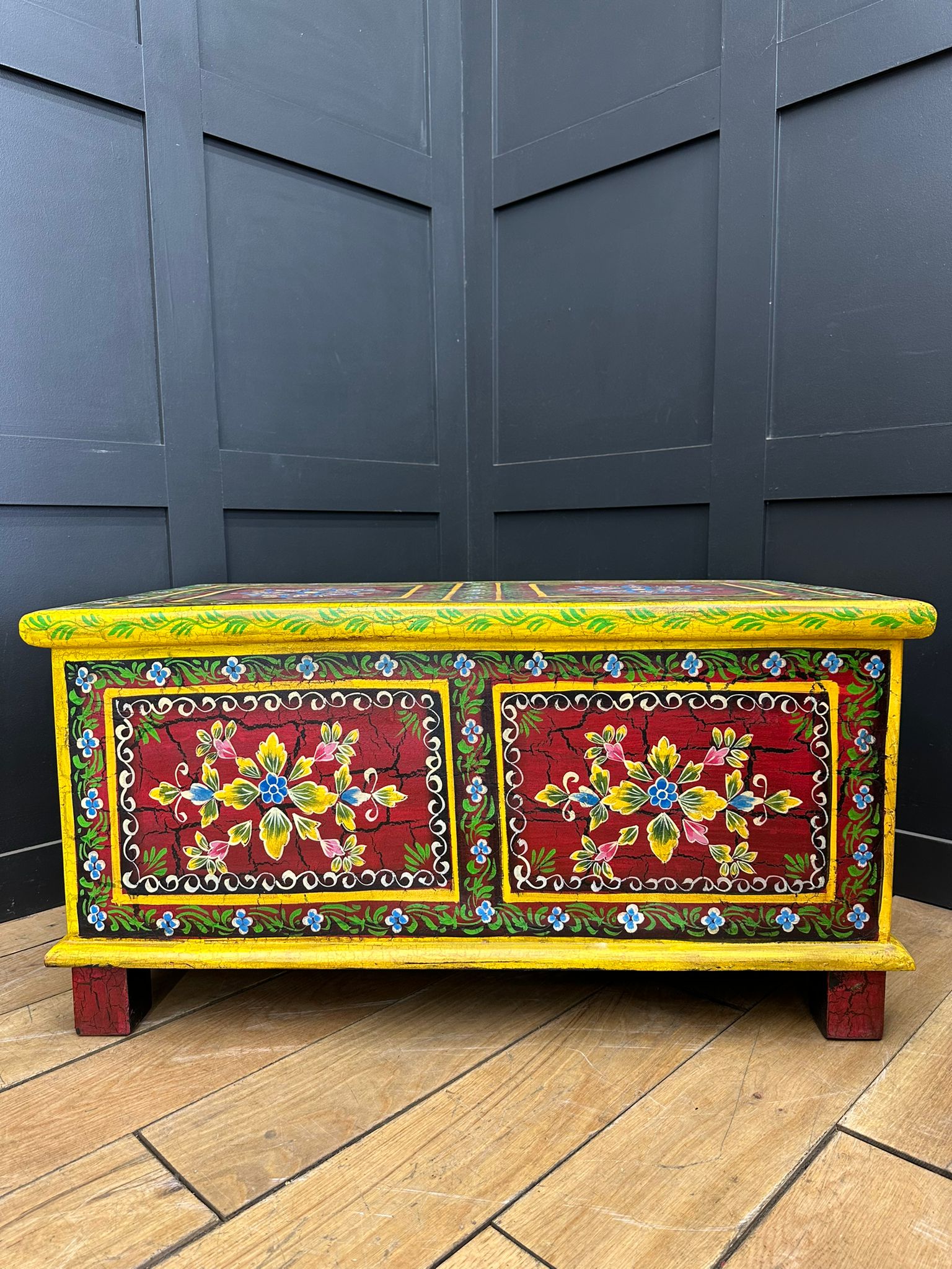 Vintage indian hand painted wooden chest with vibrant yellow and red floral panels perfect as coffee table or sideboard
