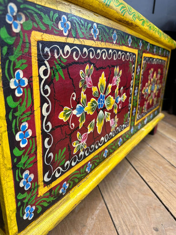 Vintage indian hand painted wooden trunk with bold red panels and floral motifs perfect as a coffee table