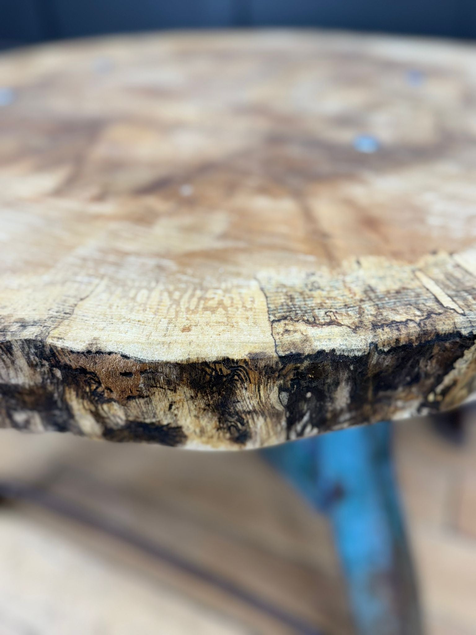 Rustic round wooden dining table with warm maple top and cast iron base perfect for vintage industrial kitchens