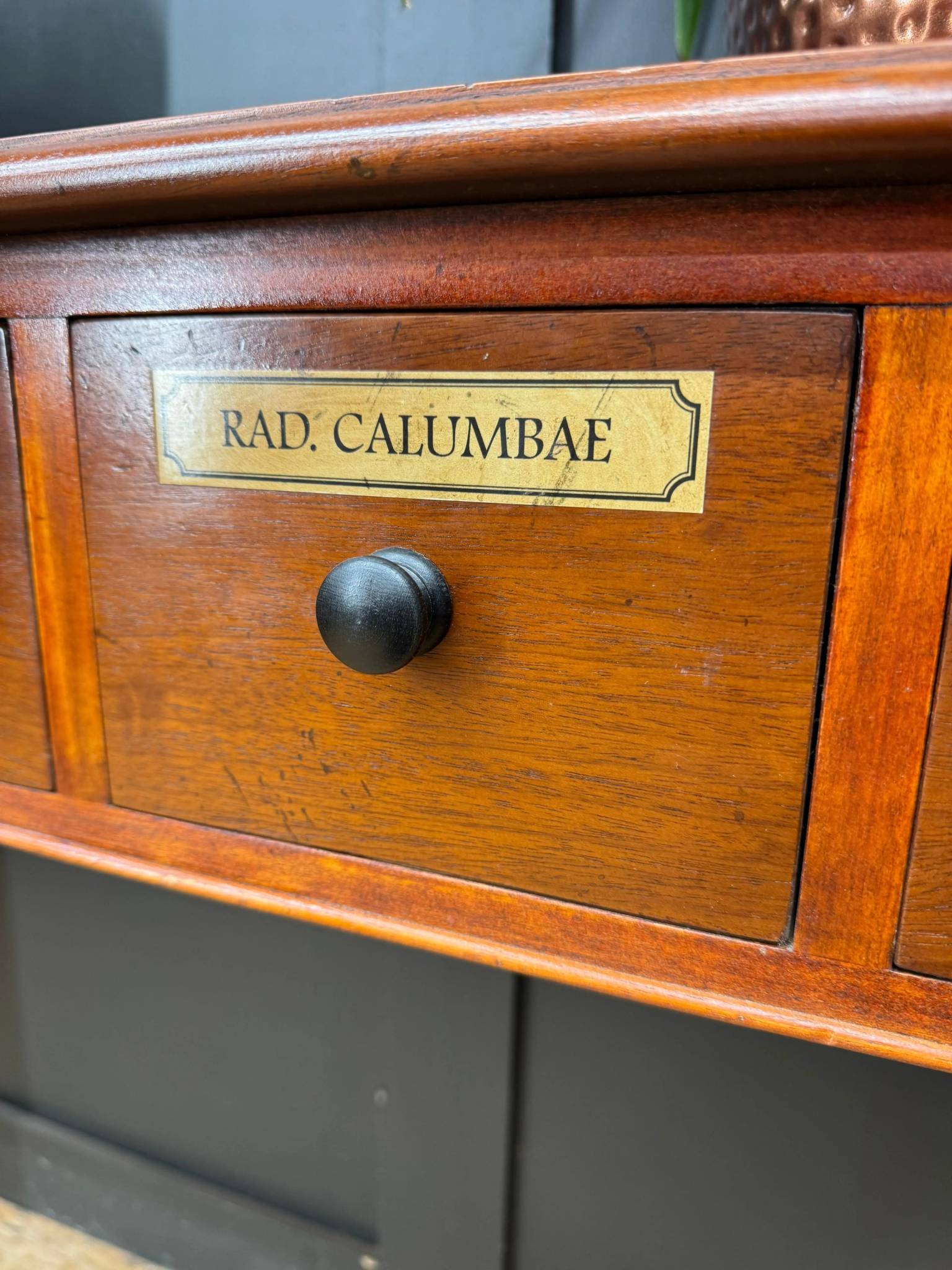 Vintage mahogany apothecary style console table drawer with polished amber finish black knob and brass label rad