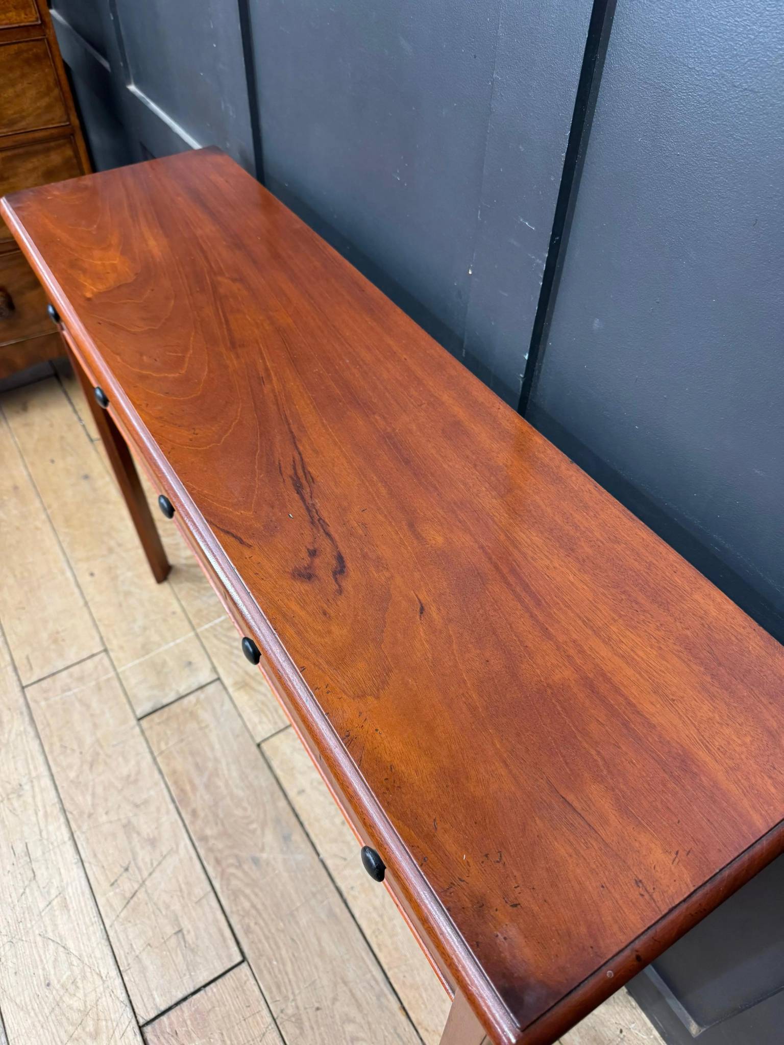 Vintage mahogany console table with smooth polished finish and dark metal drawer pulls in apothecary style design