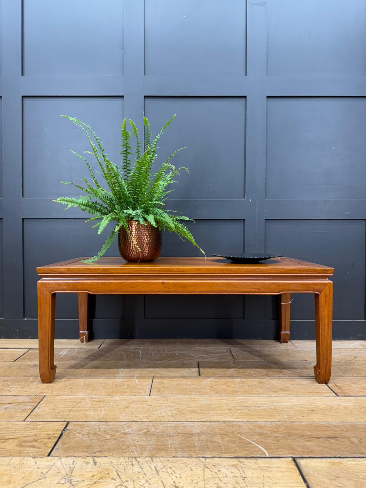 Vintage mahogany coffee table with warm amber finish rectangular top and elegantly curved legs in mid century style