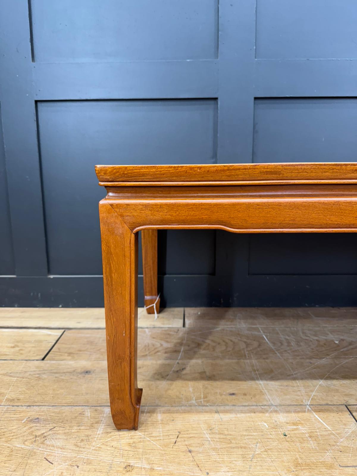 A polished medium-brown mahogany coffee table with smooth finish and traditional carved legs vintage oriental style