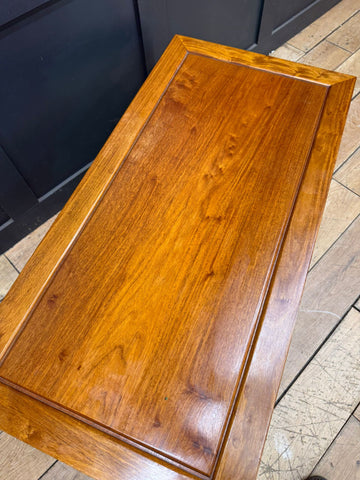 Polished golden brown vintage mahogany coffee table with smooth glossy finish and visible wood grain in mid century style