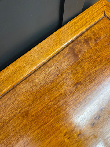 Vintage mahogany coffee table with polished golden brown wood and glossy smooth finish in mid century modern style