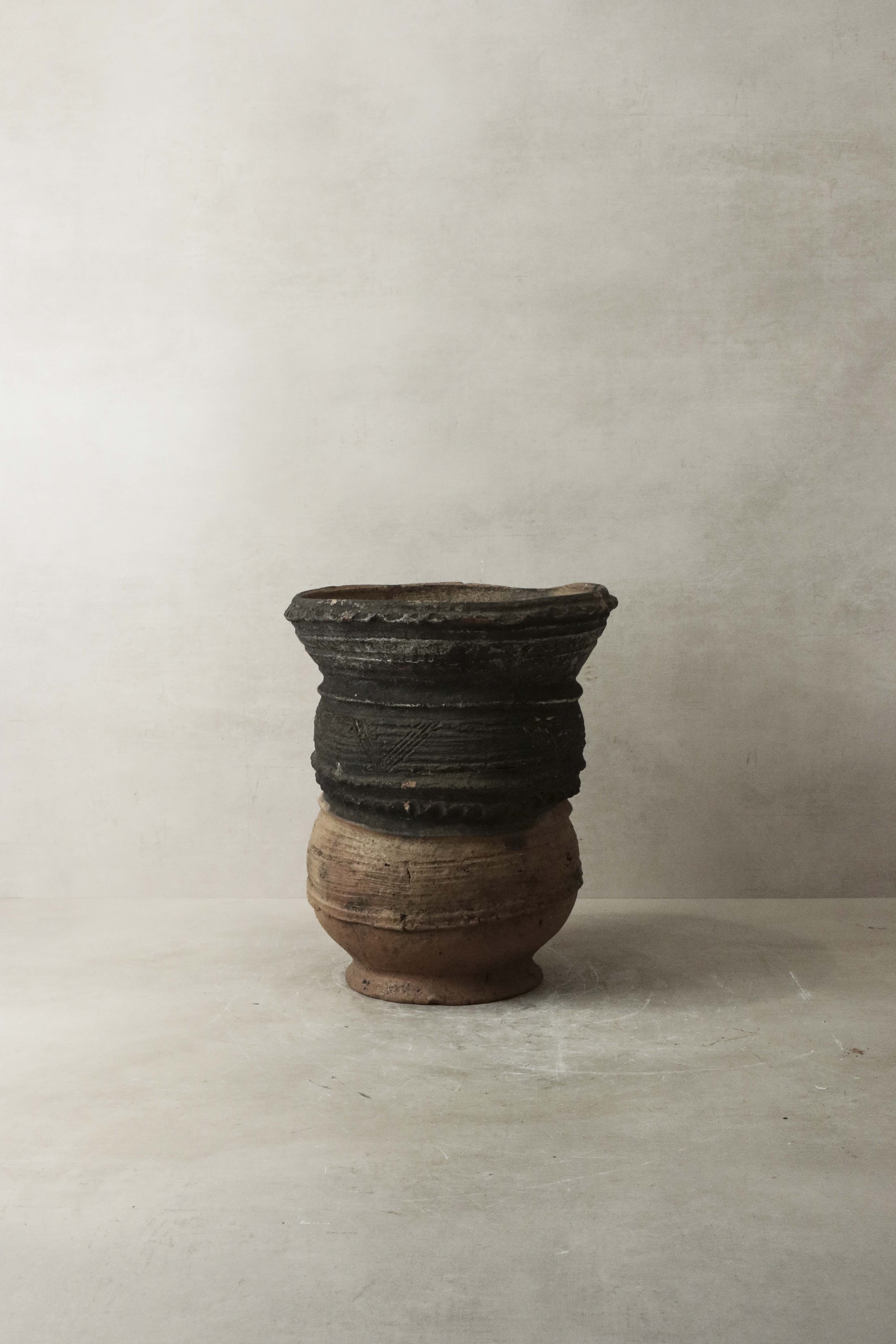 A rustic vintage nupe pot stand ceramic vessel with dark patterned top and lighter brown base perfect for display