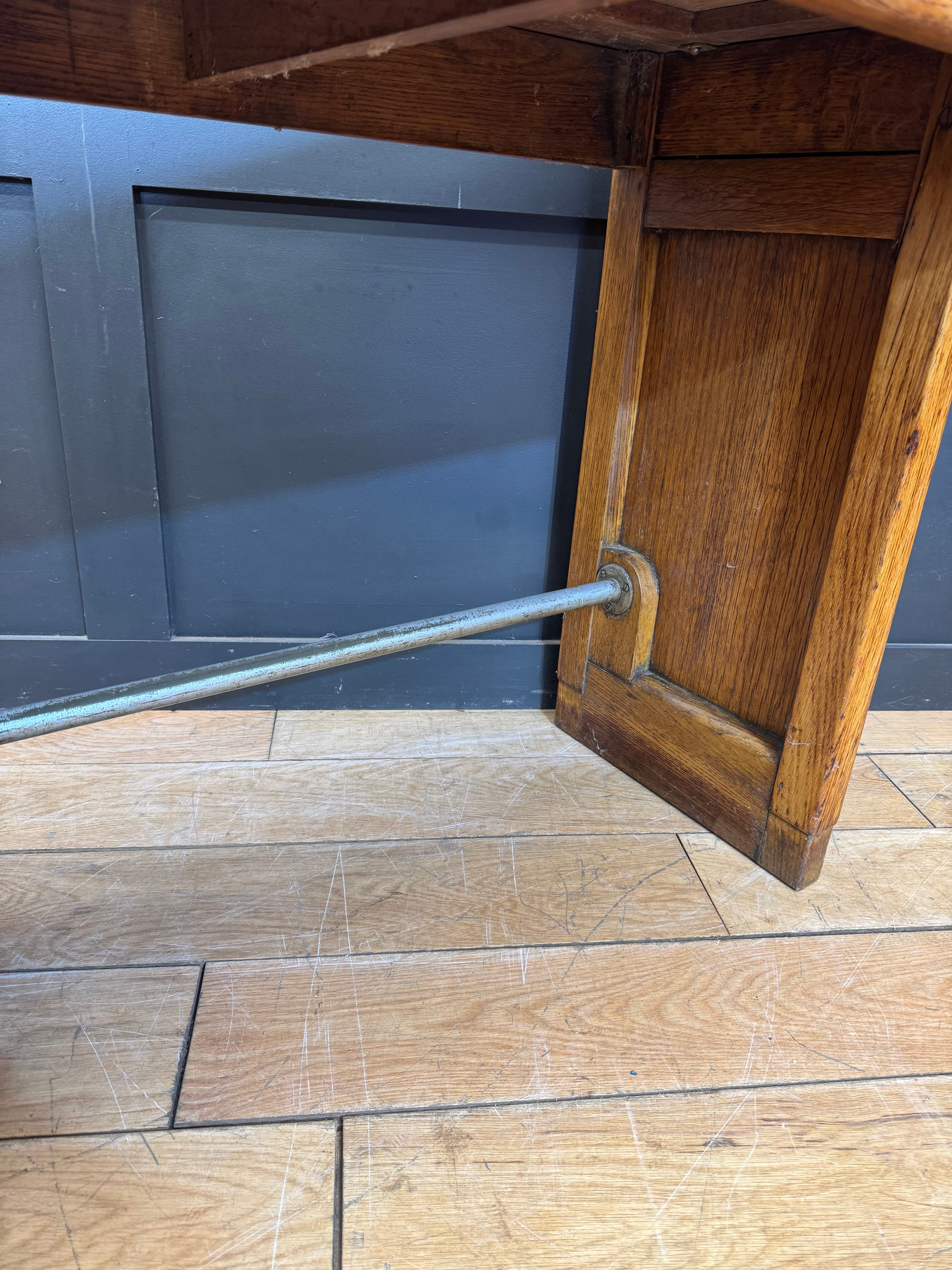 Rustic wooden leg with metal support rod on a vintage oak desk perfect for office or computer use