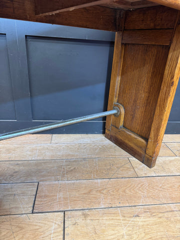 Rustic wooden leg with metal support rod on a vintage oak desk perfect for office or computer use
