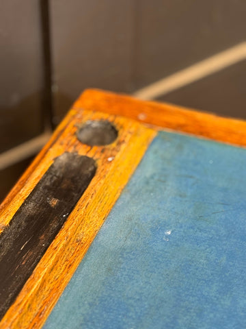 Vintage oak desk featuring a rustic orange-brown frame, faded blue surface, and dark metal hardware for desk office use