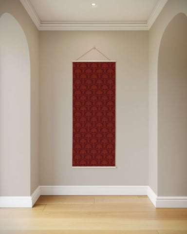 A vintage ornamental tapestry in rich burgundy damask pattern with a white wooden frame and string hanger