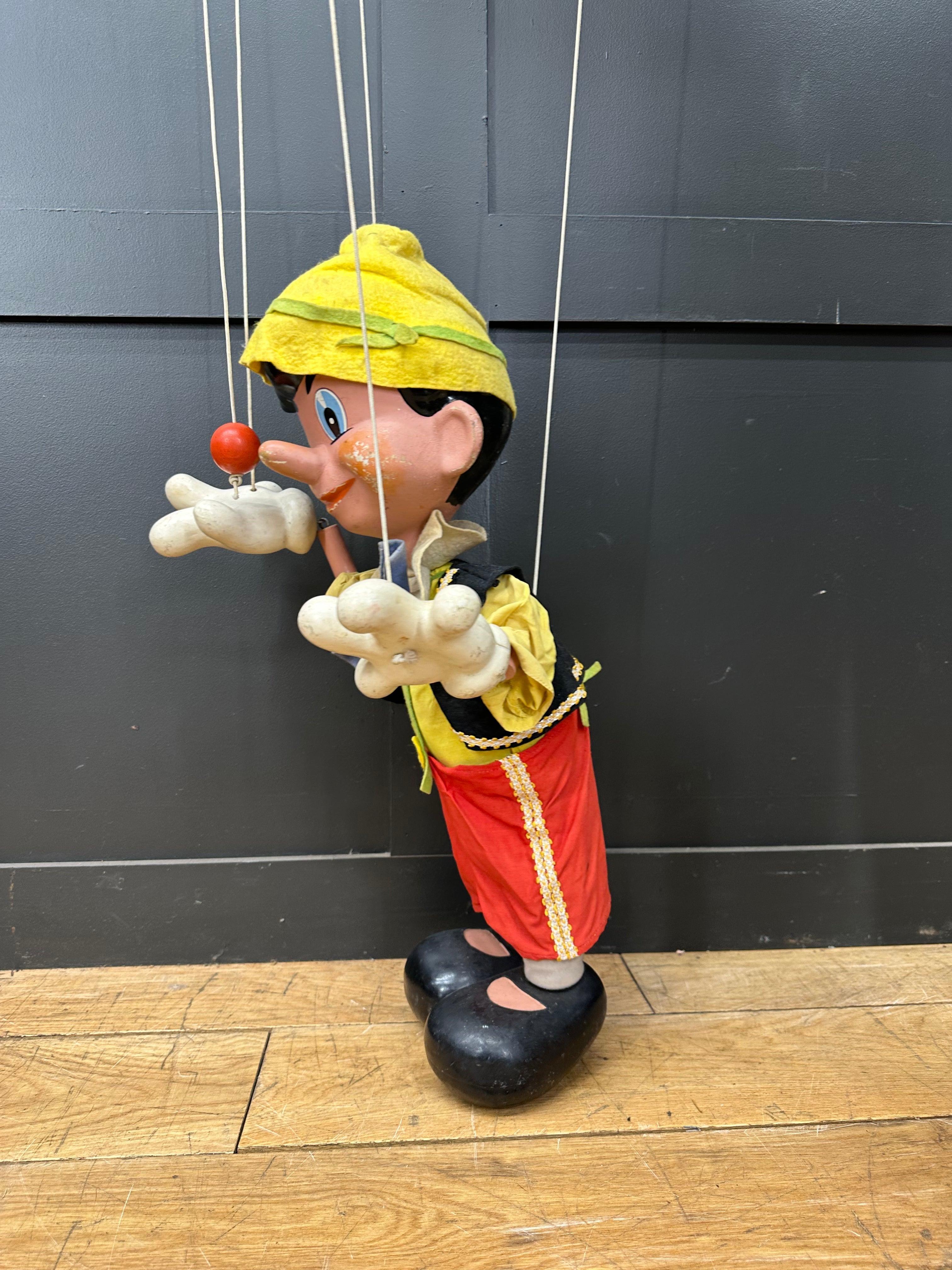 A vintage pelham puppets wooden pinocchio marionette with yellow hat red trousers and black shoes collectible rare