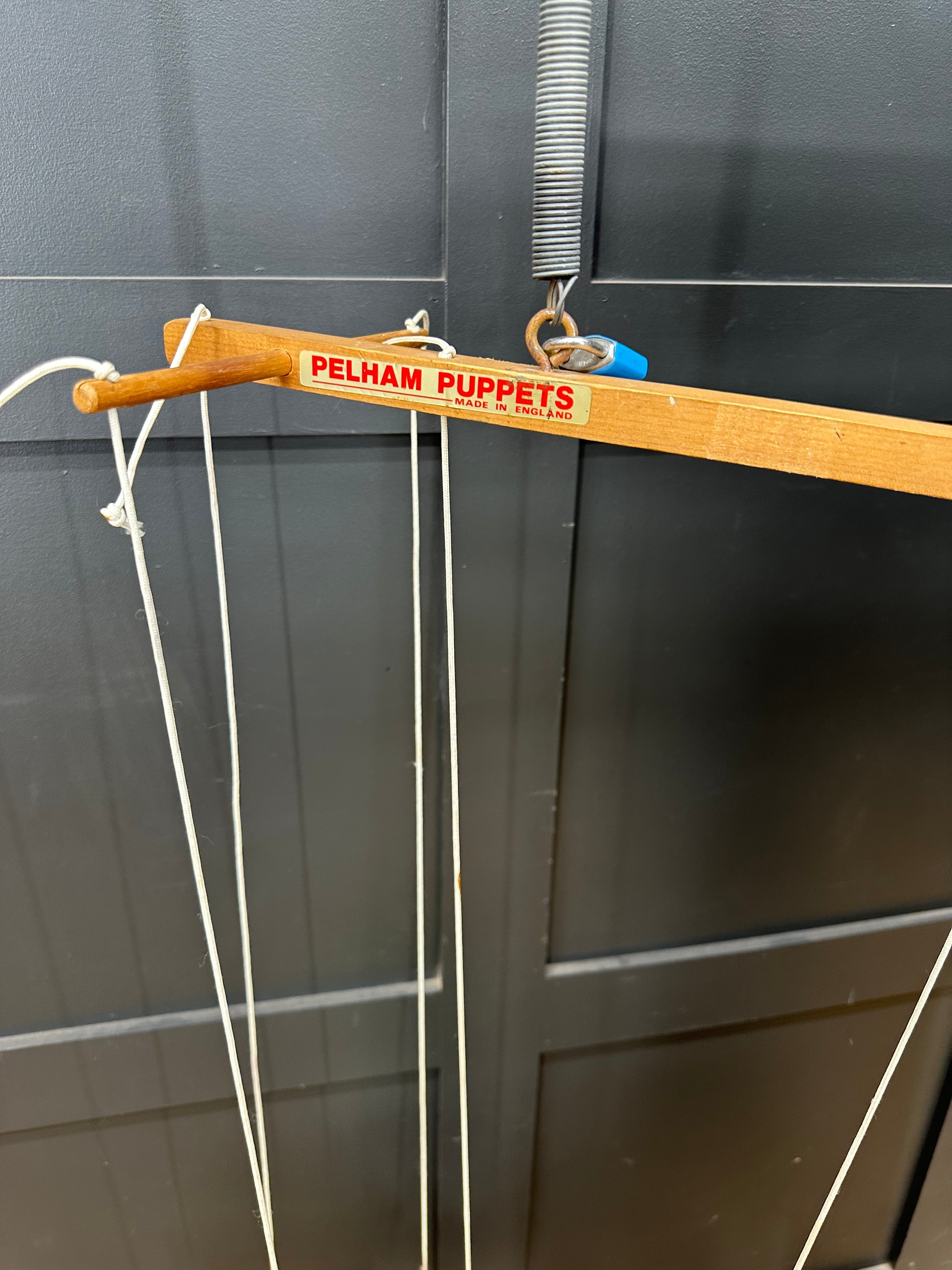 Wooden marionette control bar with red pelham puppets label and white strings for vintage pinocchio puppet collectible