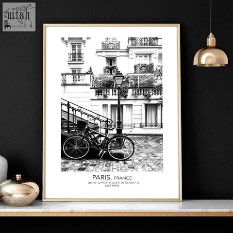 A framed black and white parisian street scene with a bicycle and paris france text in vintage wall art prints set