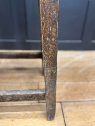 Dark brown wooden leg with visible grain and wear from a vintage railway stool mid century lner train station seat