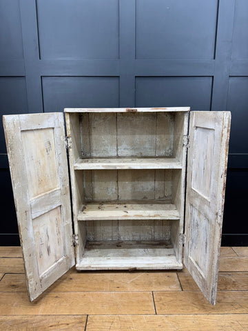 Weathered white painted wooden vintage rustic cupboard with two doors and three shelves for bathroom or kitchen use