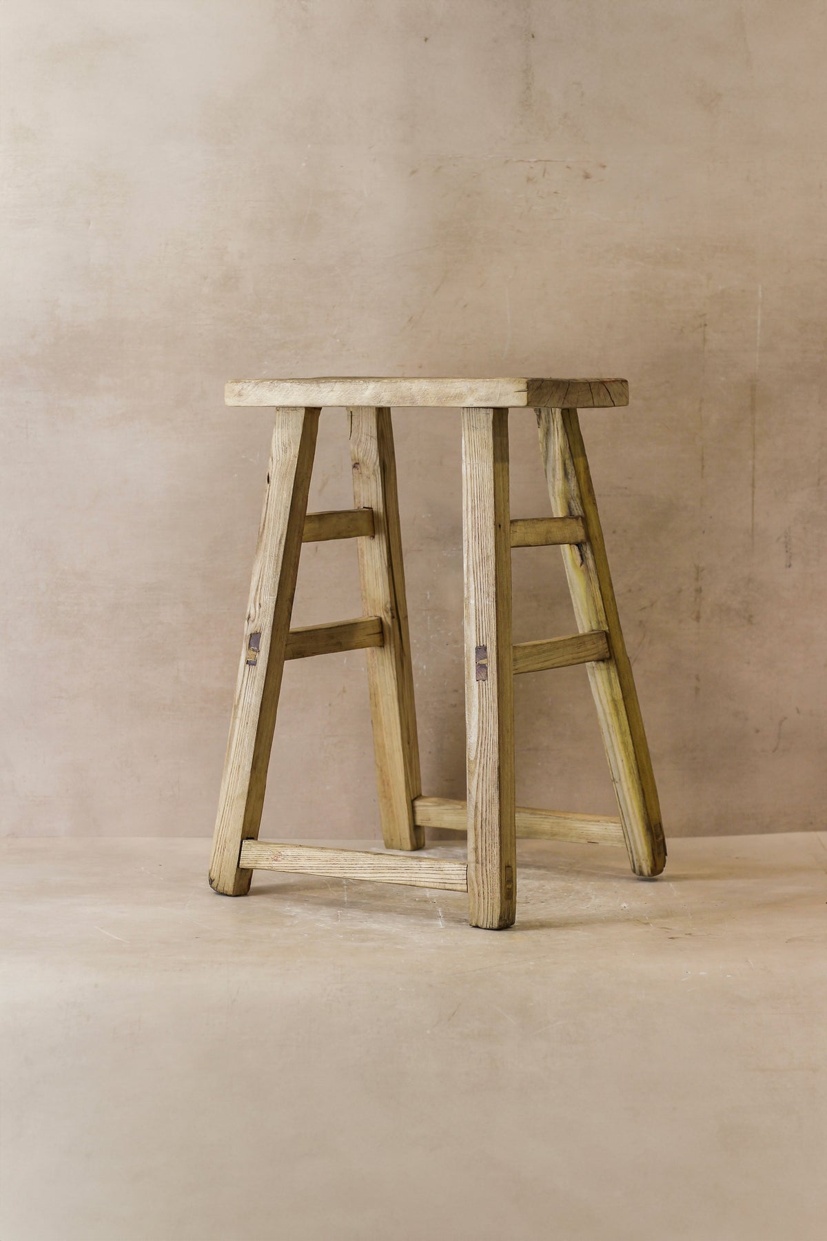 Vintage rustic elm wood stool medium with weathered light beige finish and visible grain for cozy seating