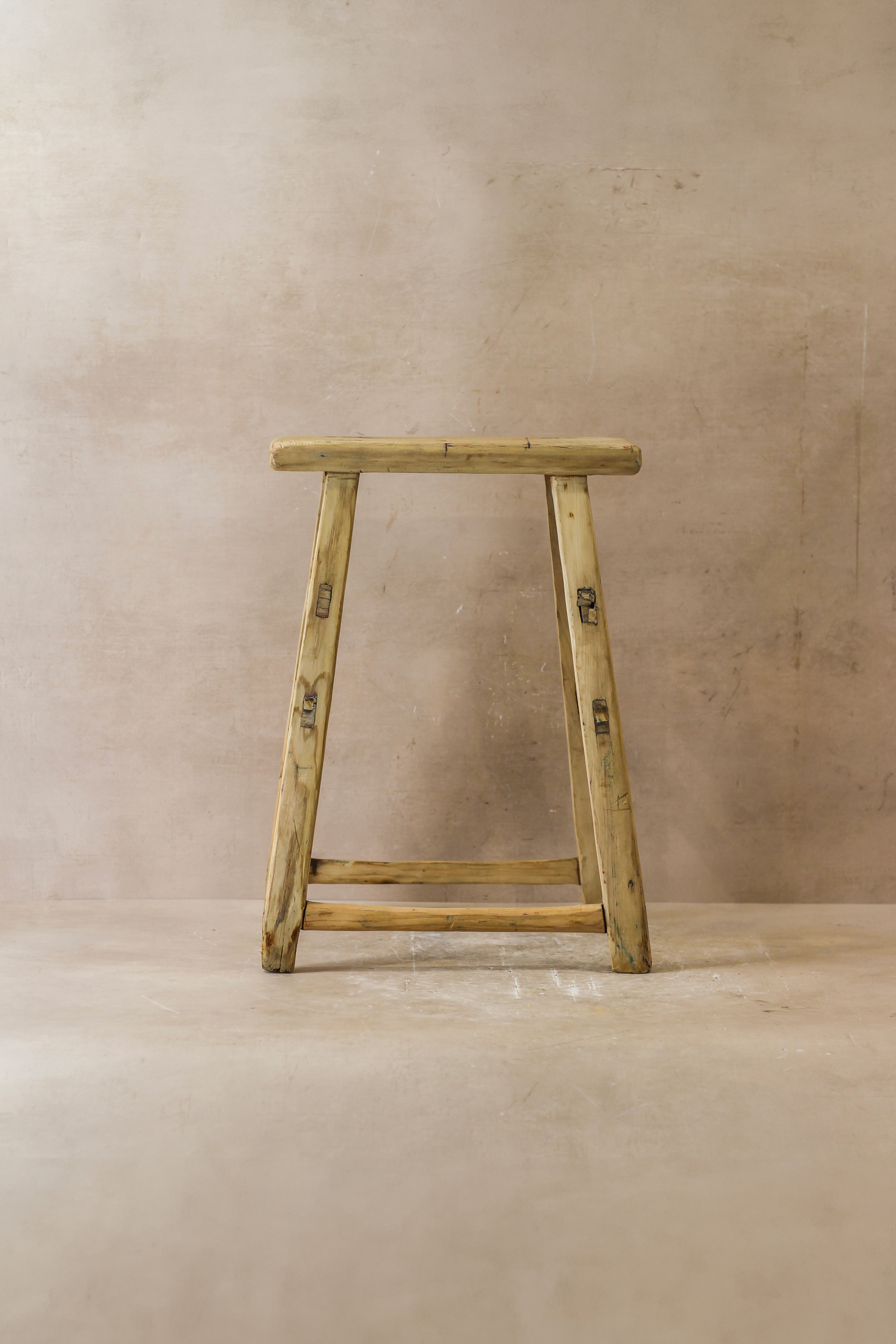 Vintage rustic elm wood stool medium with light yellow a-frame design and visible grain in elm wood finish