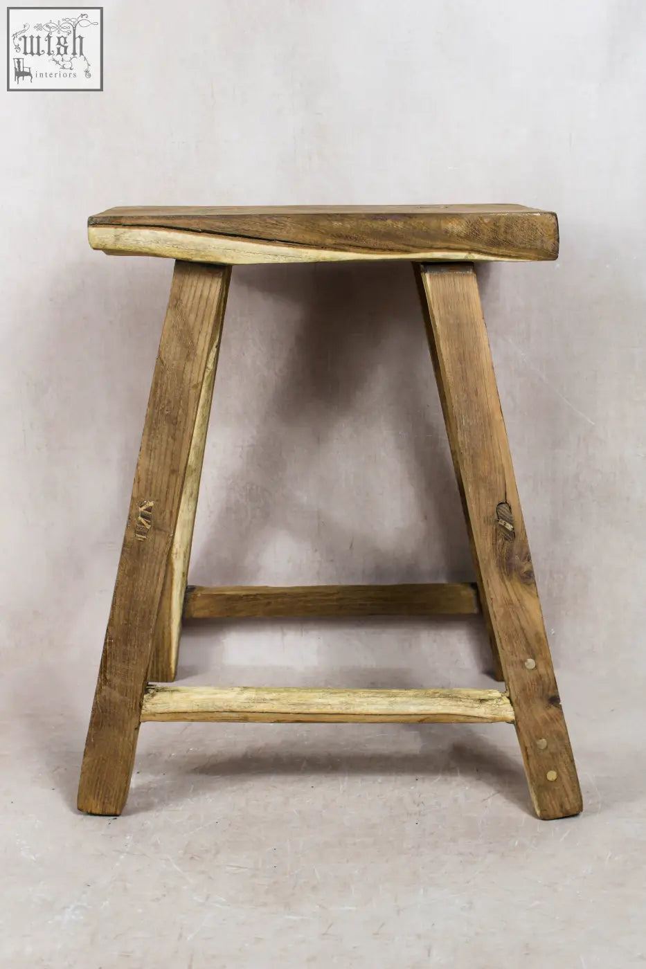 Vintage rustic elm wood stool with natural light brown finish and visible wood grain for cozy seating