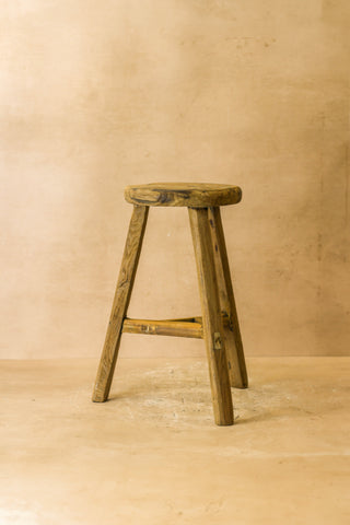 Vintage rustic elm wood stool with round top and weathered natural finish on three sturdy legs wood stool