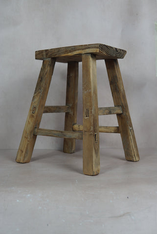 Vintage rustic elm wood stool with weathered natural finish and sturdy angled legs for timeless charm