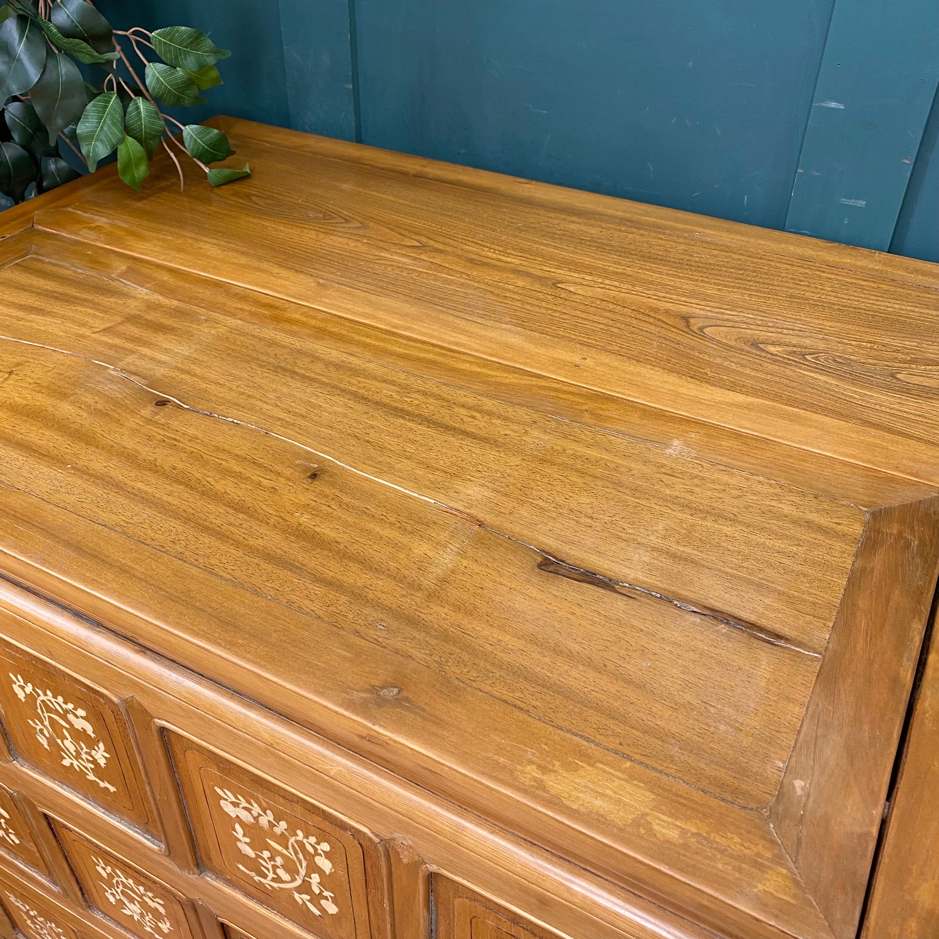 A warm polished wooden dowry chest with intricate floral inlays perfect as a vintage sideboard or cocktail cabinet