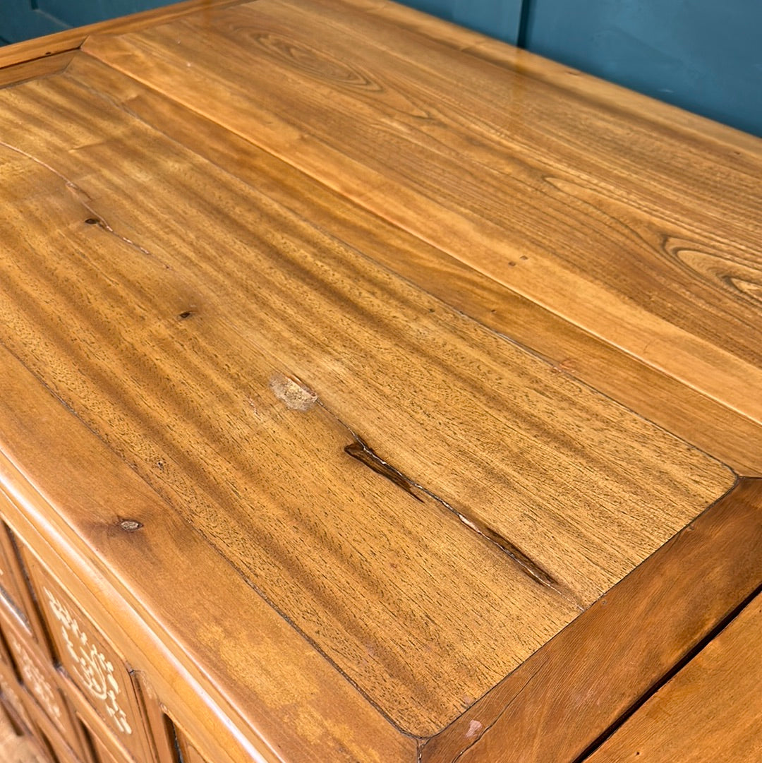 A polished wooden dowry chest with a warm golden brown finish and visible grain patterns vintage sideboard style