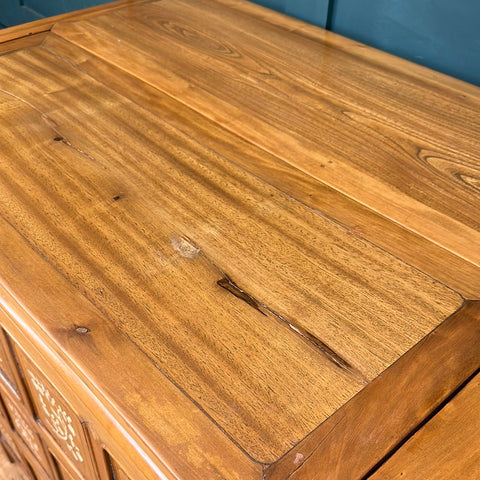 A polished wooden dowry chest with a warm golden brown finish and visible grain patterns vintage sideboard style