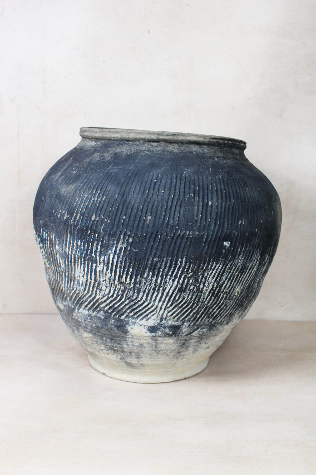 Vintage textured grey ceramic jar with vertical ridges and faded white base perfect for rustic decor